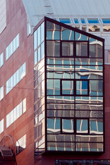 Modern Glass Office Building Facade With Reflections and Geometric Windows