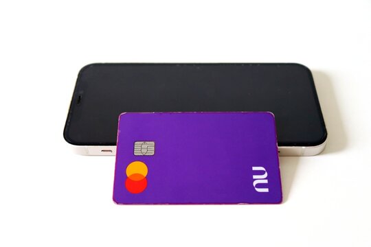 Salvador, Brazil - February 3, 2026: Nubank credit card and a smartphone. Nubank logo. Fintech. 