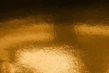 A abstract background luxurious gold-toned texture featuring a metallic, crinkled surface and soft light reflections, ideal as a rich backdrop for luxury branding, invitations, or product photography.