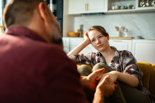 Teen girl and parent having serious conversation at home