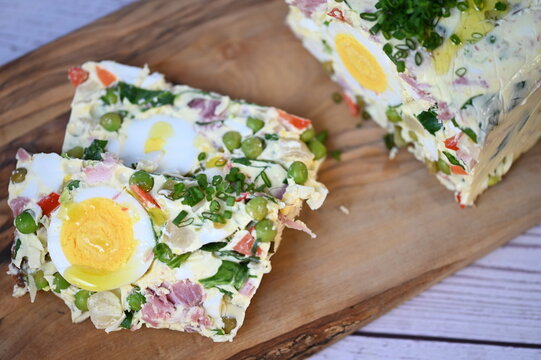 Close-up view of traditional egg aspic with peas, ham, and eggs, a colorful festive food background associated with Easter celebrations and Czech cuisine.
