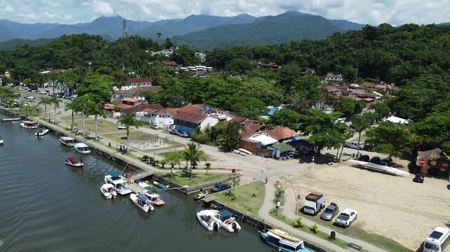 Small leisure crafts sailing out of a river and moored along it in Baia de Paraty in Brazil