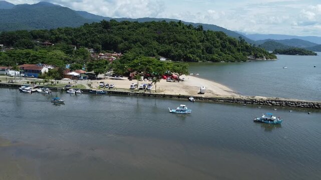 Drone footage of small boats sailing out of a river and into Baia de Paraty in Brazil