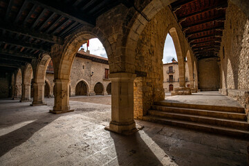 Obraz premium The arcaded town hall square in Cantavieja, Teruel, Aragon, at midday light