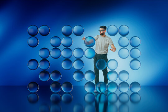 Man interacting with floating blue 3D spheres in studio environment