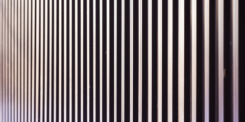 Obraz premium A close view of a wall built from vertical metal slats, creating a repeating pattern