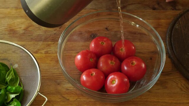 Woman cooking sauce with fresh tomato at the kitchen