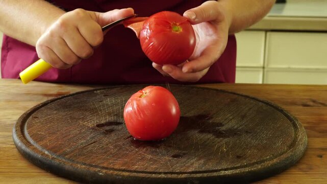 Woman cooking sauce with fresh tomato at the kitchen