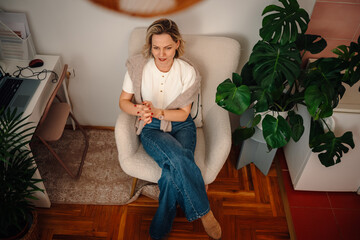 Woman relaxing in comfortable armchair at home