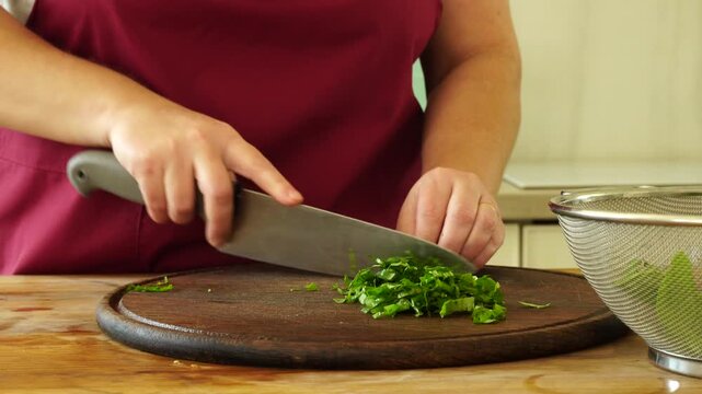 Woman cooks and using fresh basil leaves from bush