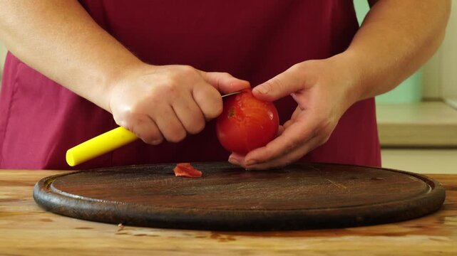 Woman cooking sauce with fresh tomato at the kitchen