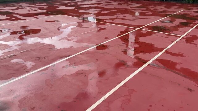 Wet Surface of Clay Tennis Court with Large Rain Water Puddle 