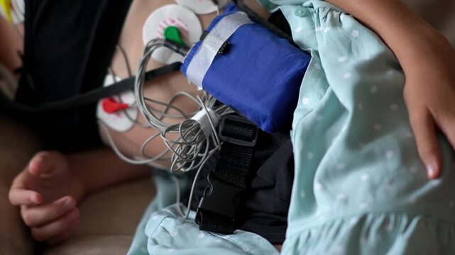 close up of girl with medical equipment undergoing heart examination. Heart monitoring. Girl with heart monitor resting on sofa