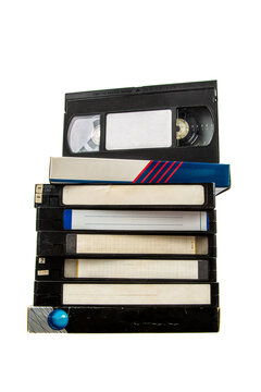 Stack of vintage VHS tapes with blank labels on a white back