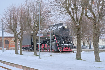 Naklejka premium Old steam locomotive in the snow on the tracks of tapa ralway station, Estonia 
