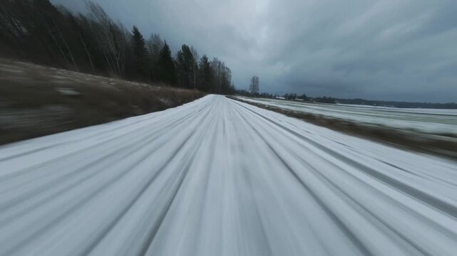 FPV drone flyby of red wooden barn on snowy winter dy