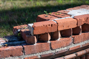 A damaged little red brick wall