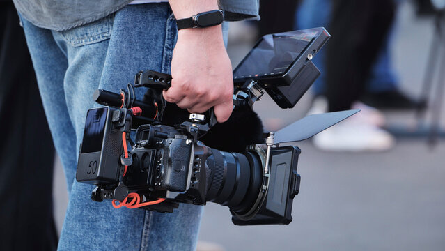 Videographer holding professional cinema camera rig filming production