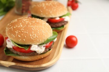 Delicious burgers with meat patties on white table, closeup. Space for text