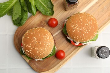 Naklejka premium Delicious burgers with meat patties on white table, flat lay