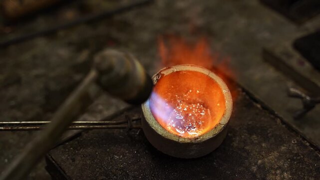 Manual gold melting using a torch before casting jewelry 4k video. Gold being melted by torch during jewelry production.