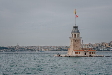 Obraz premium A wide view of the Maiden’s Tower rising from the waters of the Bosphorus under an overcast sky. 