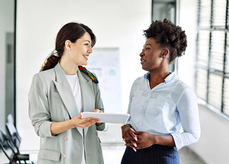 Portrait of two young business woman having a meeting or presentation and seminar standing in the office. Portrait of a young business woman talking
