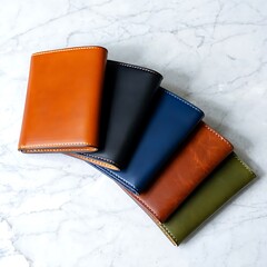 Leather wallets in different colors on marble surface