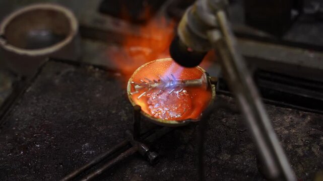 Jeweler melting silver in a crucible during the jewelry casting process 4k video. Molten silver in the crucible being heated to casting temperature as part of jewelry production.