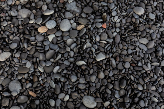 Top down macro texture of smooth basalt pebbles on Reynisfjara Black Sand Beach, Iceland