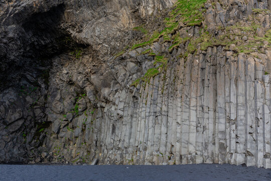 Geometric hexagonal basalt columns inside Halsanefshellir Cave at Reynisfjara Black Sand Beach, Iceland