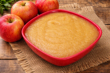 Compote de pommes maison dans un bol rouge avec pommes fra&icirc;ches