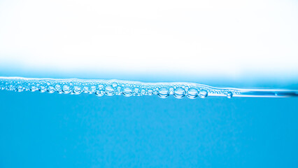 Blue water surface with air bubbles, clean liquid texture, macro underwater line, purity and...