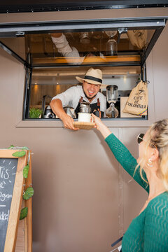 Coffee truck barista serving customer at motorhome window