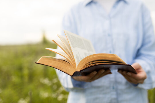 Woman reading an open Bible outdoors