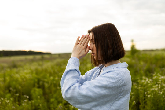 Woman praying in a serene field