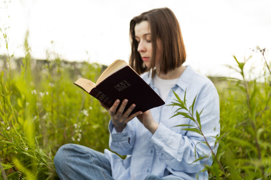 Woman reading the Bible outdoors in nature