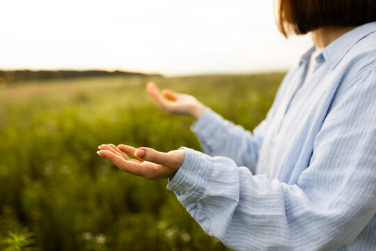 Woman praying in a serene outdoor setting