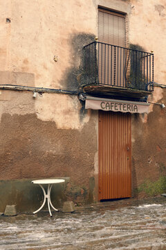 Rustic cafeteria facade with table and balcony