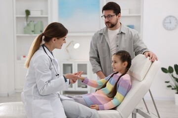 Obraz premium Little girl and her father having appointment with doctor in hospital