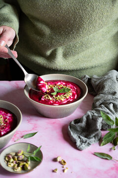 Creamy beetroot cream garnished with pistachios and fresh sage