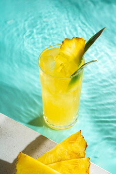 Refreshing pineapple juice in a glass by the pool