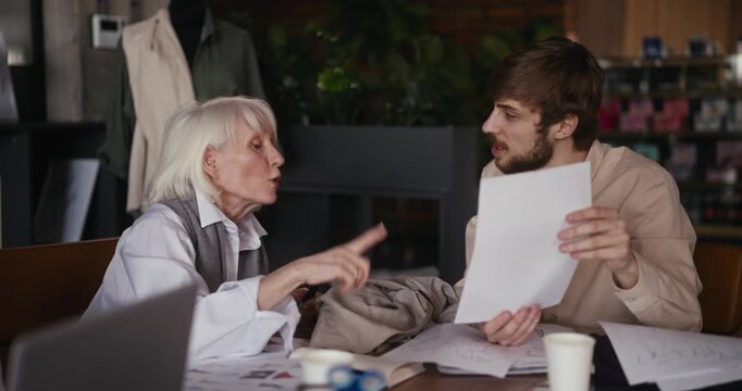 two passionate designers sharing sketches and fabric ideas over coffee