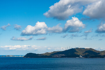 風力発電の風車のある島と青空