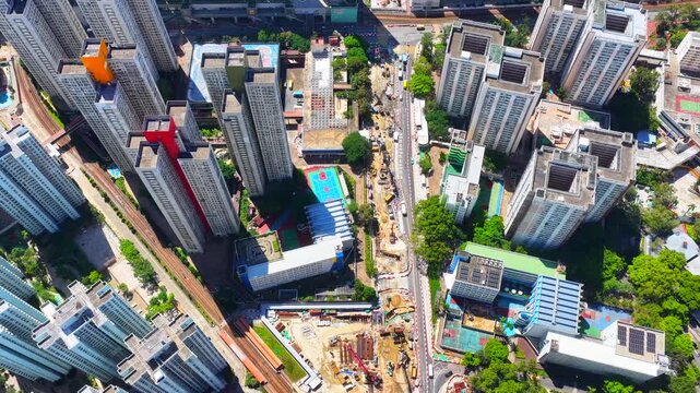 Aerial skyview of Tuen Mun subway extension project in Hong Kong, featuring elevated railway construction along Tuen Mun River and road, new station development and temporary work platforms