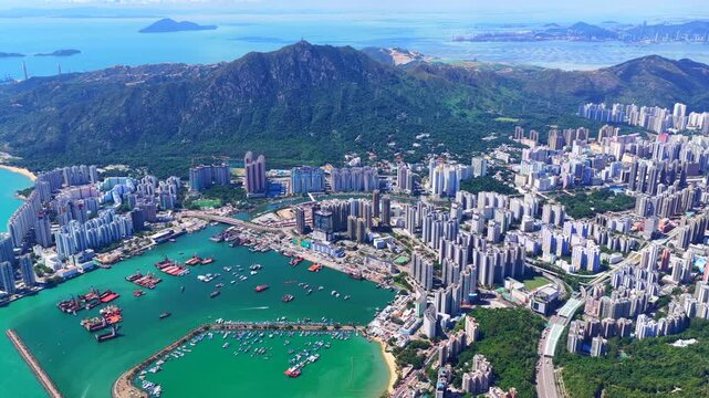 Aerial skyview of Tuen Mun subway extension project in Hong Kong, featuring elevated railway construction along Tuen Mun River and road, new station development and temporary work platforms