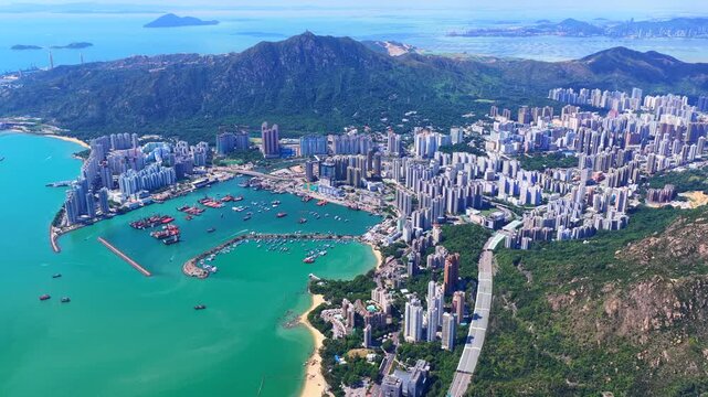 Aerial skyview of Tuen Mun subway extension project in Hong Kong, featuring elevated railway construction along Tuen Mun River and road, new station development and temporary work platforms