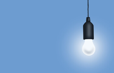 An electric light bulb suspended on a black wire insulated on a blue background.