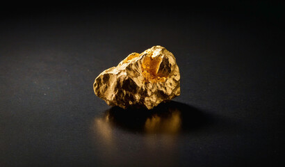Natural Gold Nugget on Reflective Black Surface. Shiny Raw Precious Metal Ore. Luxury Concept of Mining Geology, Financial Wealth, Investment, Economy Market, Rare Mineral and Expensive Texture. © stefanbalaz