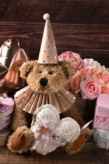 Vintage style teddy bear holding a heart and celebrating birthday or Valentines Day